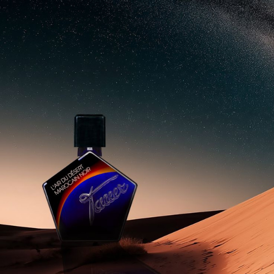 Andy Tauer L'Air du Désert Marocain Noir Elixir, tiefblauer Flakon in nächtlicher Wüstenlandschaft mit Sanddünen und Sternenhimmel inszeniert, erhältlich bei scent amor.