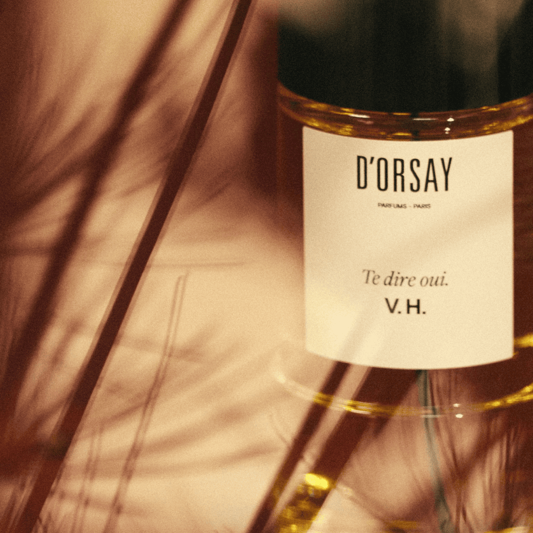 Atmosphärische Detailaufnahme von Te dire oui. V.H. Eau de Parfum von D’Orsay, eleganter Glasflakon in warmem Licht inszeniert, erhältlich bei scent amor.