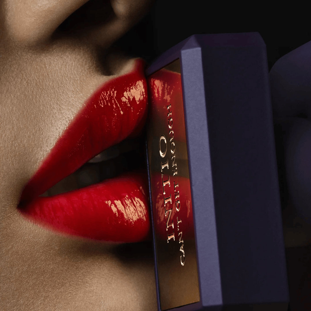 Initio Parfums Privés Can’t Get Enough Extrait de Parfum – Flakon inszeniert vor roten Lippen, Symbol für Verführung und Intensität bei scent amor