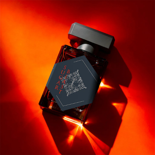 Initio Parfums Privés Sugar Blast Eau de Parfum, Flakon inszeniert in warmem rotem Licht mit starken Schatten, sinnliche und kraftvolle Duftpräsentation, erhältlich bei scent amor.