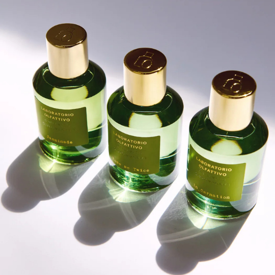 Laboratorio Olfattivo Eau de Parfum Jasminade, Rose Me Twice und IN_CARNATION, drei olivgrüne Flakons mit goldenen Kappen im eleganten Lichtspiel arrangiert, erhältlich bei scent amor.