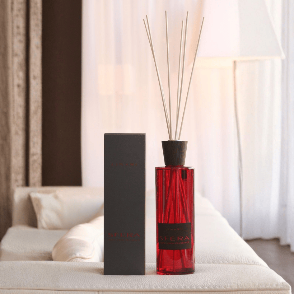Linari Sfera Diffuser mit Verpackung, roter Raumduft-Flakon im eleganten Wohnraum, warm, stilvoll und einladend, erhältlich bei scent amor.