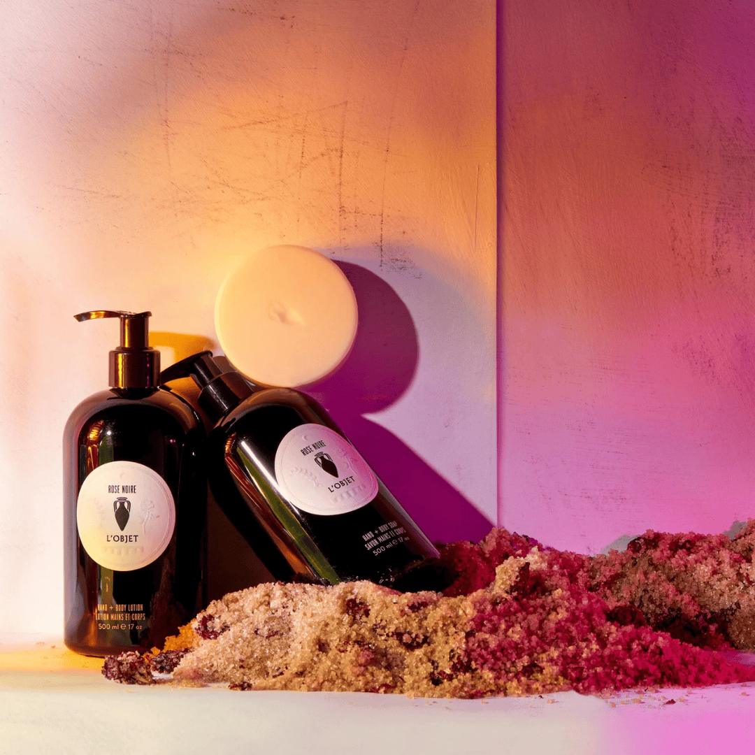 L’Objet Rose Noire Hand + Body Soap, stilvolle Präsentation mit Handlotion und Seife in schwarzer Flasche, sinnlicher Duft von Rose Noire, inszeniert mit warmen Lichtakzenten, erhältlich bei scent amor.