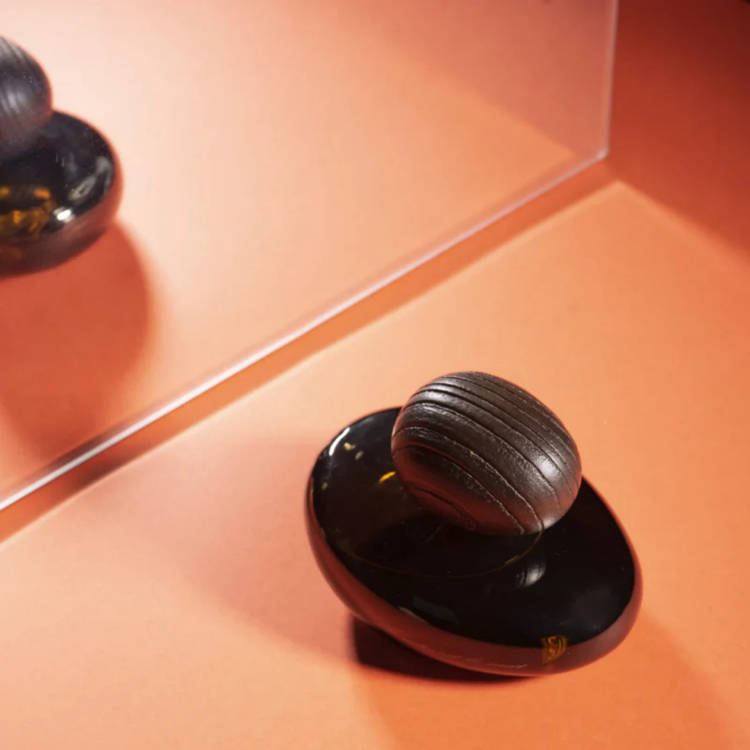 Majda Bekkali Tendre est la Nuit Obscur Extrait de Parfum, inszeniert mit Spiegelung auf warmem Hintergrund, elegant und modern, erhältlich bei scent amor.