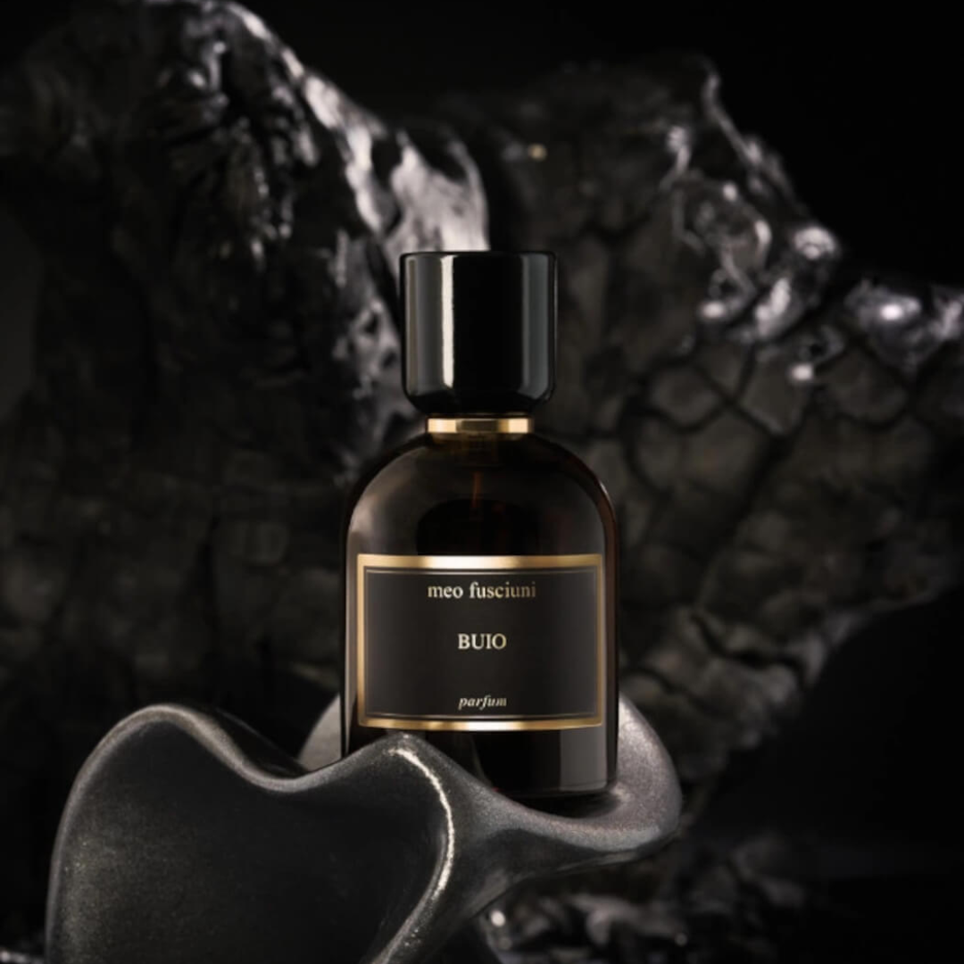 Meo Fusciuni Buio Parfum, ein intensiver Nischenduft mit dunklen, erdigen und rauchigen Facetten, atmosphärisch inszeniert vor tiefschwarzer, mineralischer Struktur, erhältlich bei scent amor.