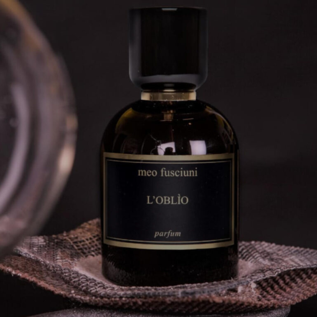 inszenierter Flakon von dem Eau de Parfum L’Oblio von Meo Fusciuni auf Textilien mit Glas, warmer dunkler Duft mit ruhiger, nachdenklicher Atmosphäre, erhältlich bei scent amor.