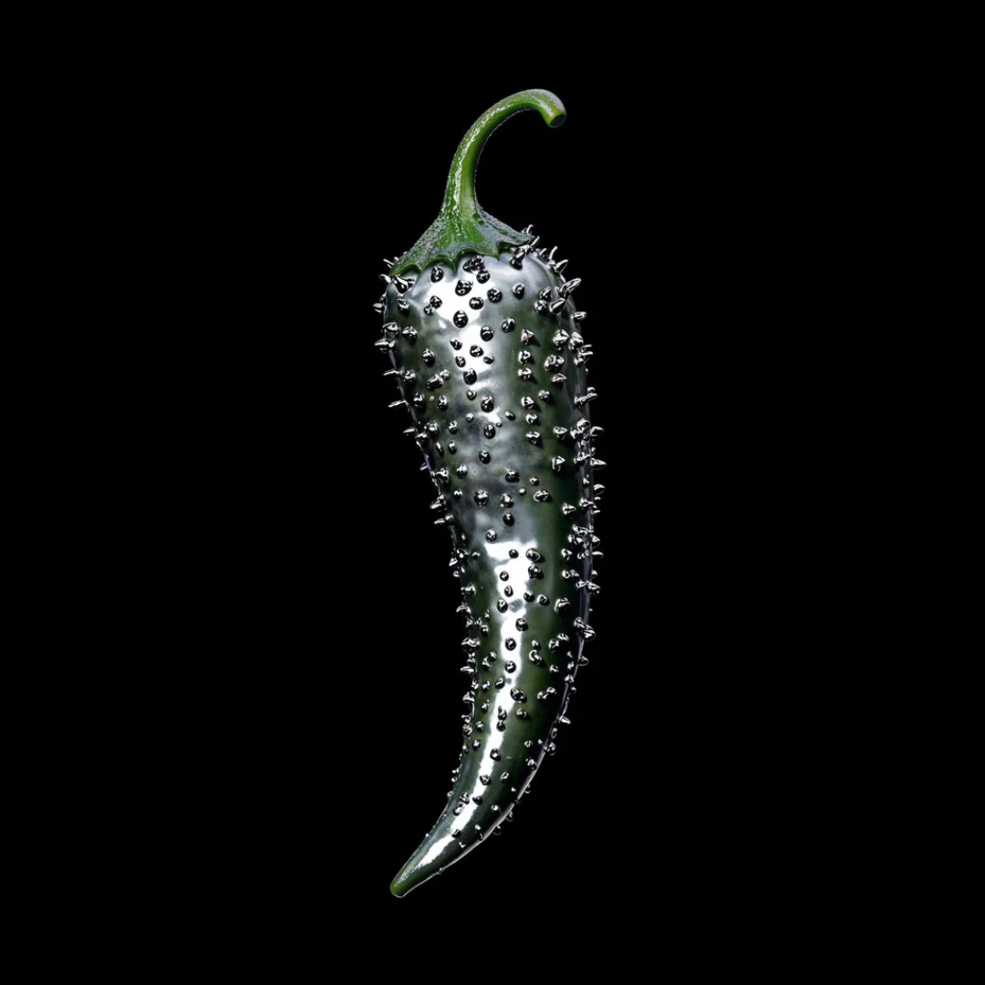 Première Peau Gravitas Capitale Extrait de Parfum – Chilischote mit metallischen Nieten als künstlerisches Detailbild, Sinnbild der Duftintensität bei scent amor