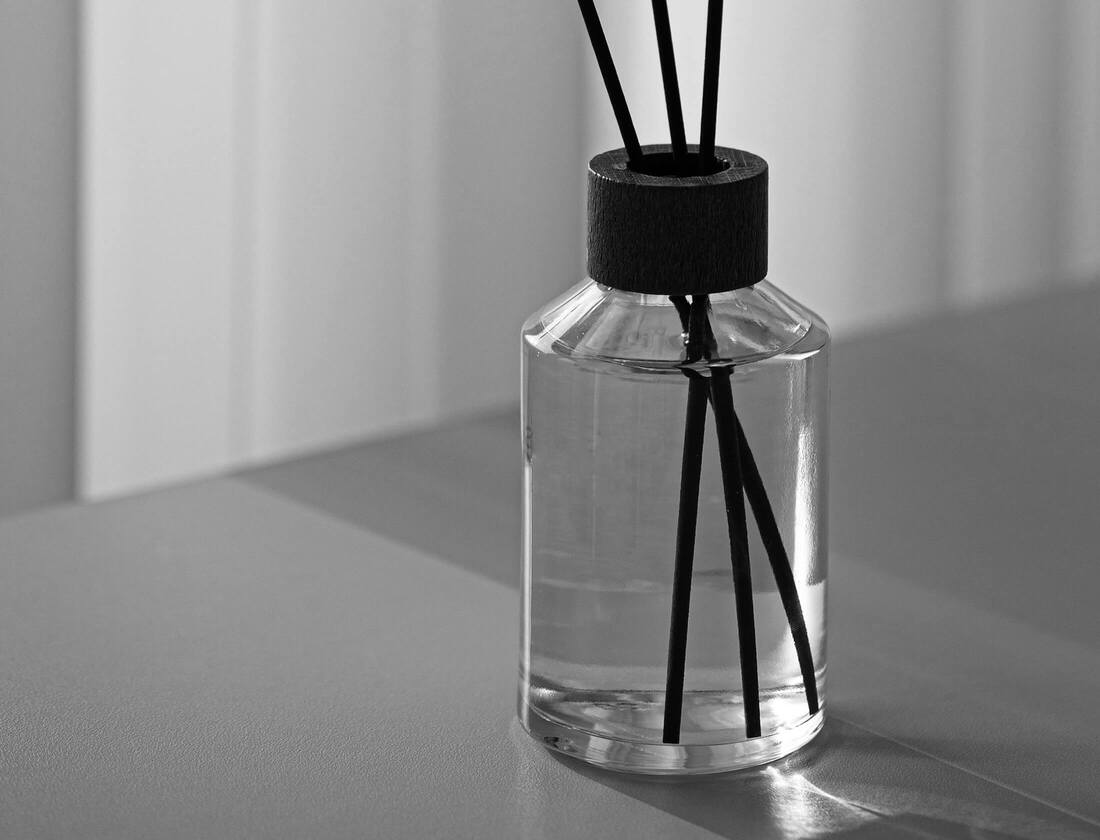 Ein Raumduftdiffusor mit Duftstäbchen auf einem Tisch.