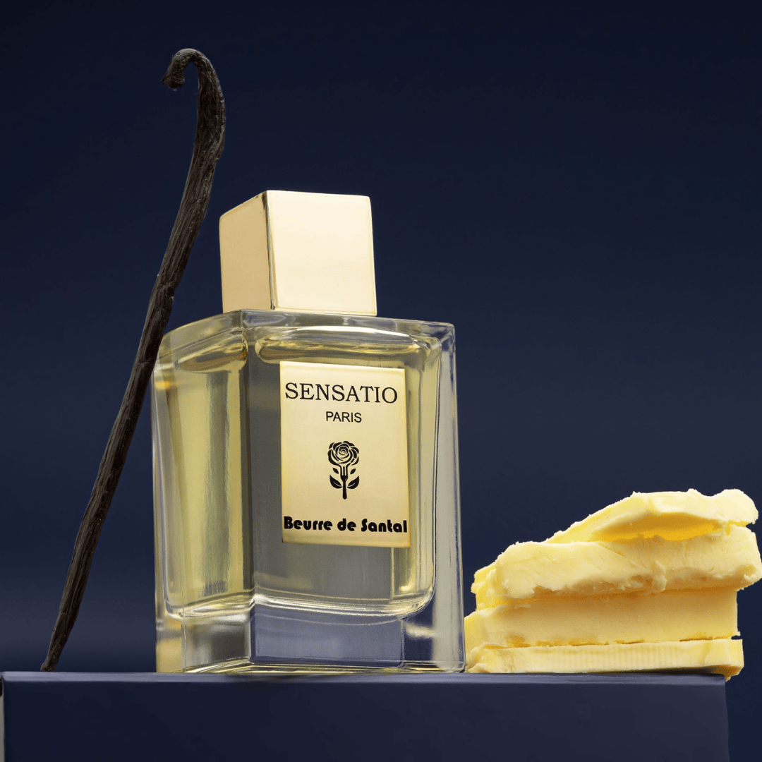 Sensatio Paris Beurre de Santal Eau de Parfum, elegante Präsentation des Flakons mit Vanille und Butterelements auf dunklem Sockel, erhältlich bei scent amor.