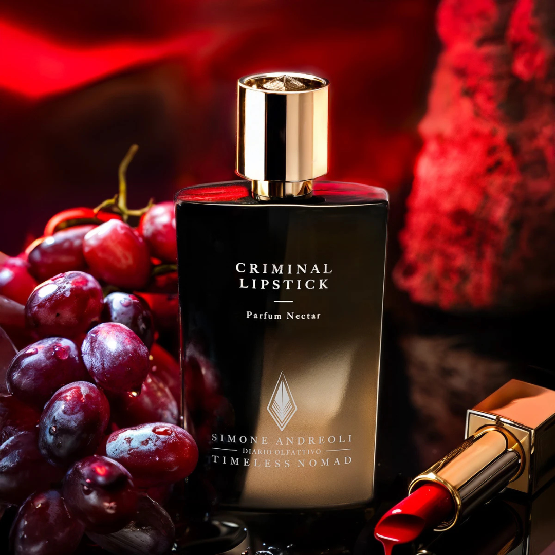 Simone Andreoli Criminal Lipstick Parfum Nectar – Flakon kunstvoll inszeniert mit Weintrauben und Lippenstift, Sinnbild für Sinnlichkeit und Leidenschaft bei scent amor